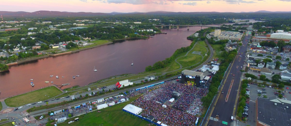 aerial photo of bangor and brewer maine with waterfront concert happening