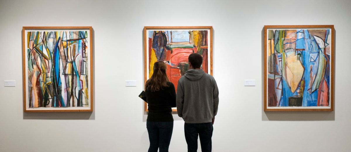 photo of man and woman admiring art at an exhibit